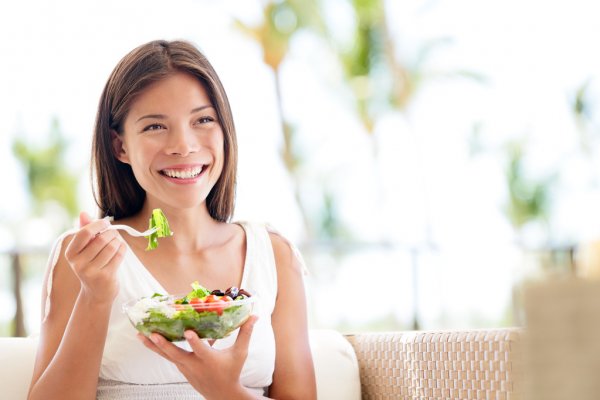 Mulher alimentando-se de salada
